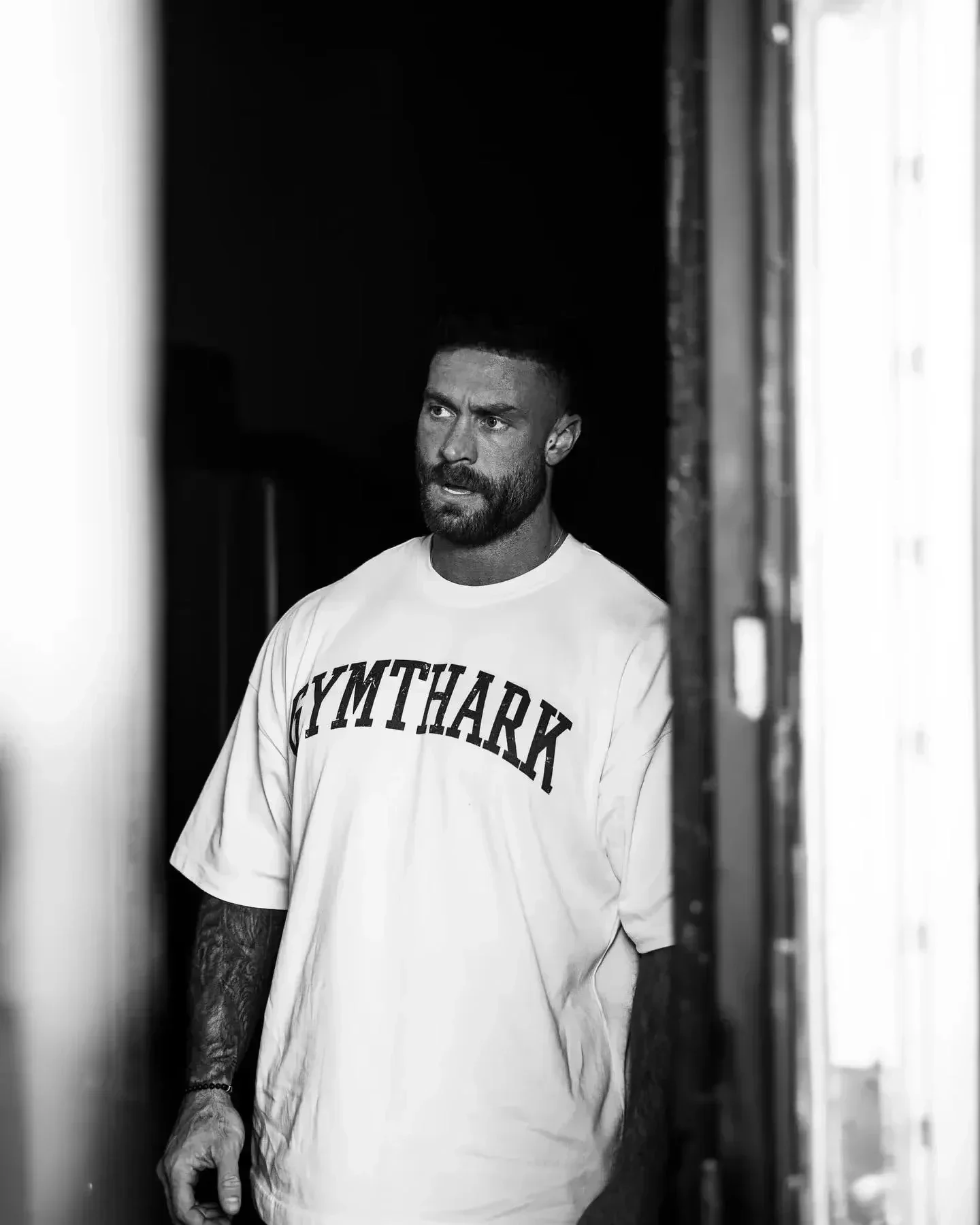 A person lifting dumbbells while sitting on a bench in a modern gym setting.